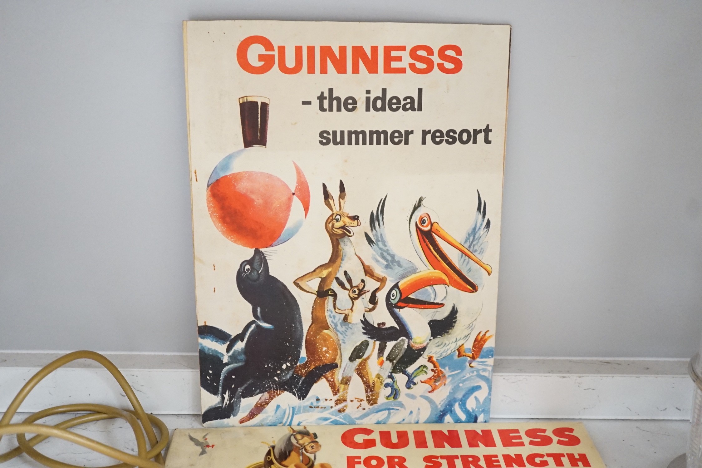 Five Guinness advertising signs, mirror, trays and a book - St. James’s Gate Brewery History and Guide